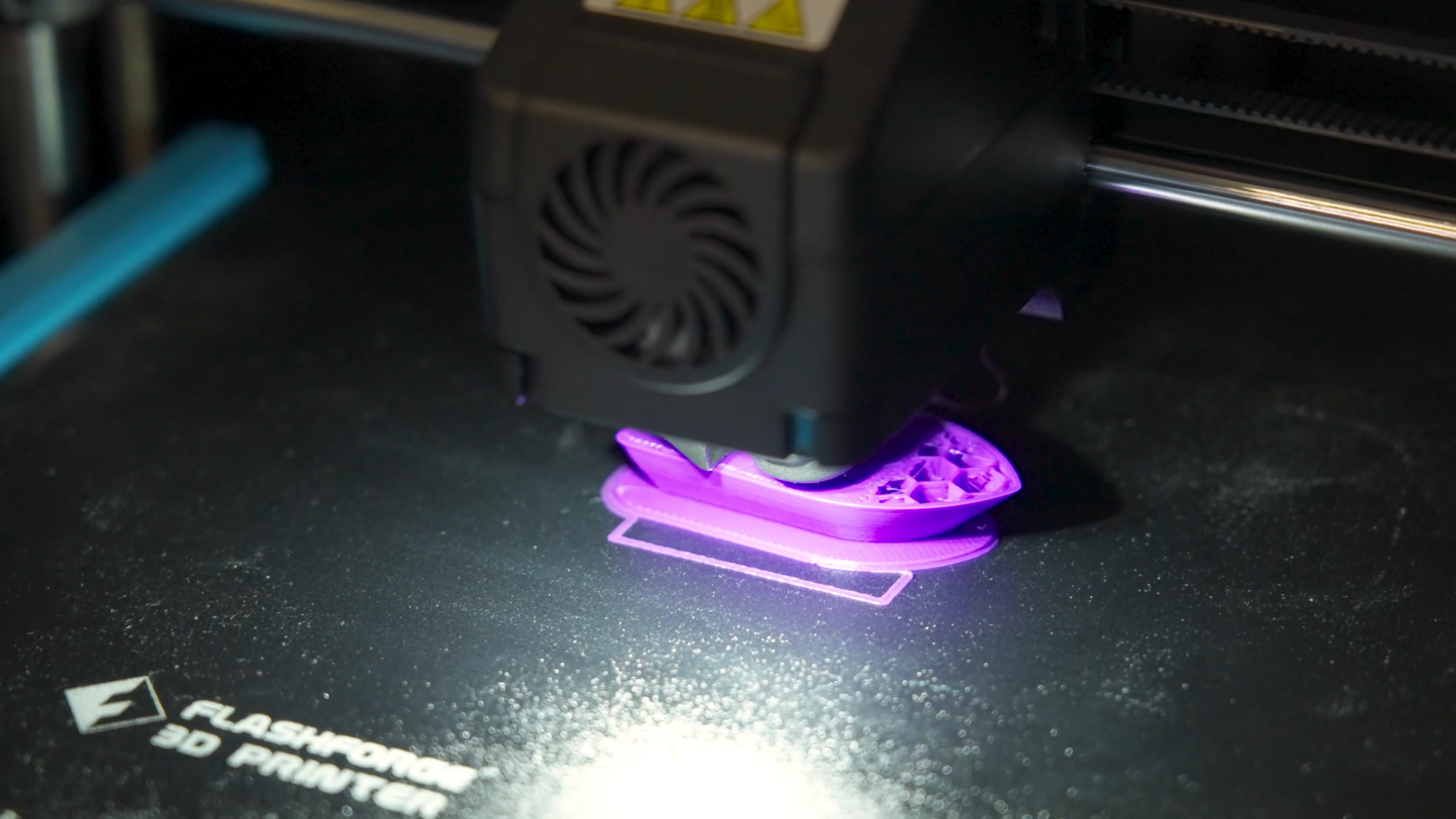3D printer printing with purple filament.