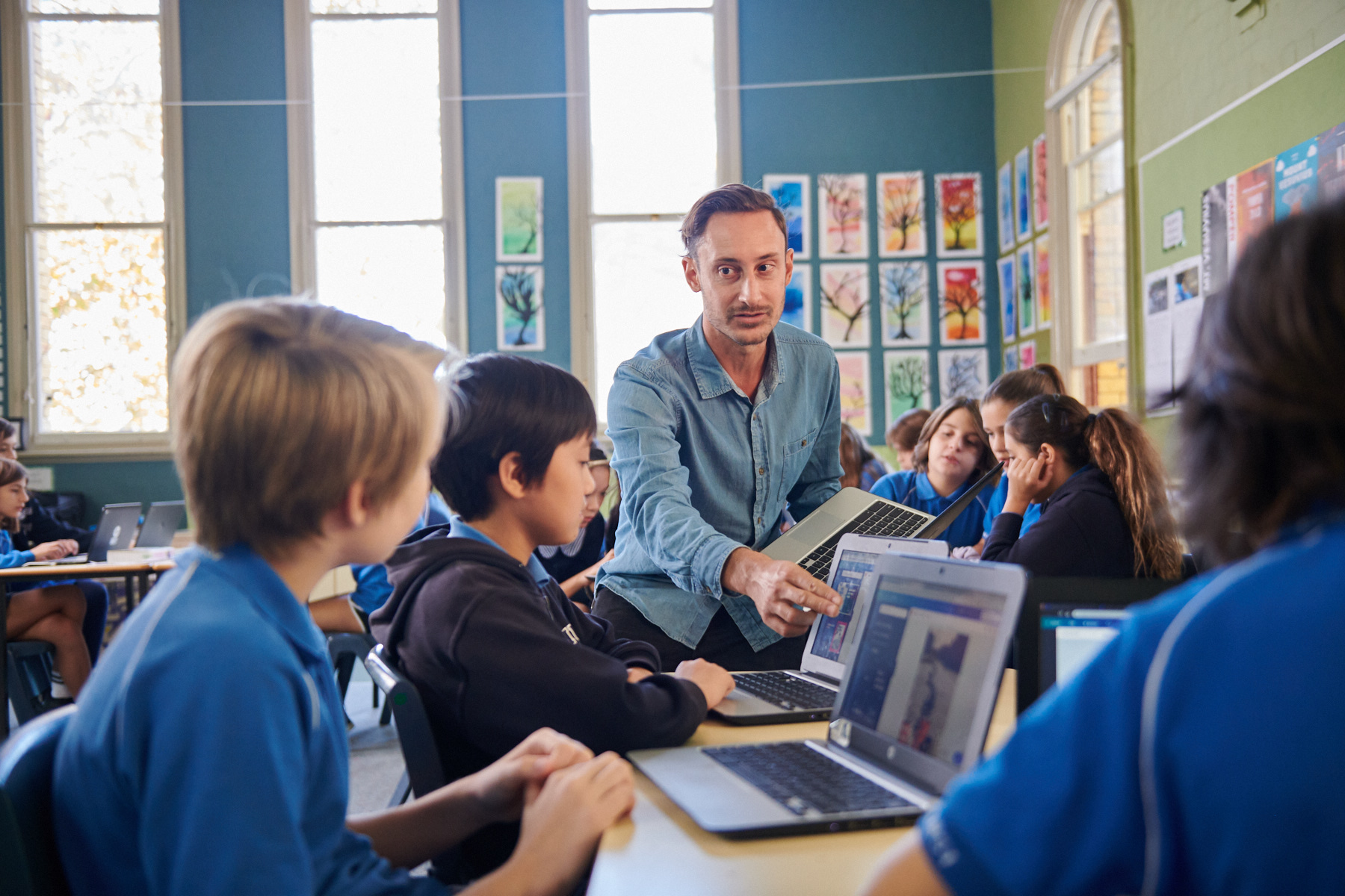 Teacher with students using Canva for Education in a classroom.