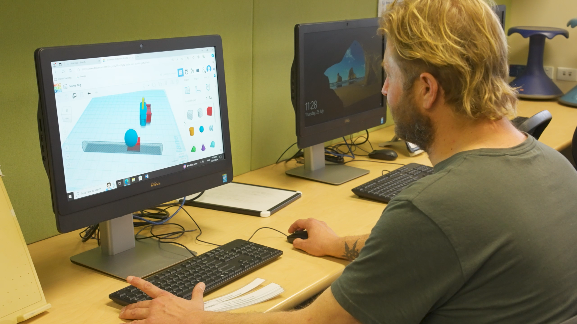 Teacher working on a computer designing a 3D object in TinkerCAD.